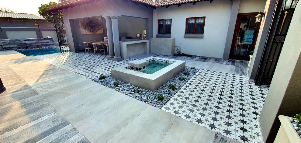 Mid-sized mediterranean courtyard patio in Other with a water feature, tile and no cover.