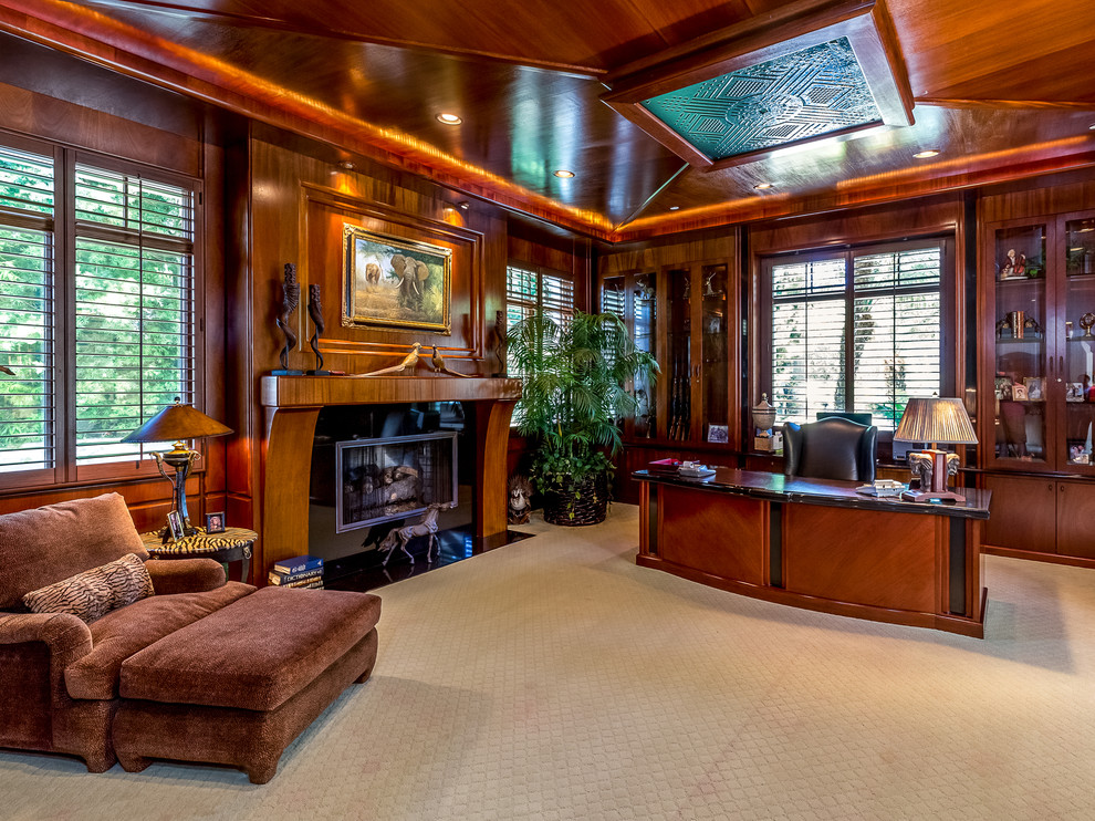 Photo of an expansive traditional study room in Orange County with carpet, a standard fireplace, a freestanding desk and a stone fireplace surround.