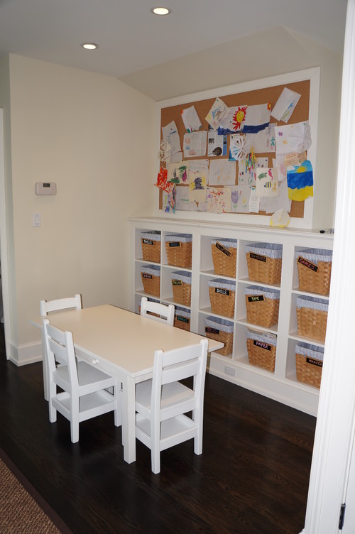 Learning corner with table and chairs, a bulletin board, and cubbies with baskets