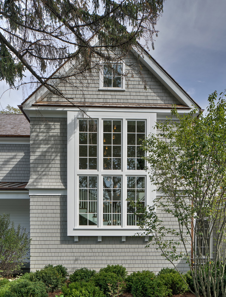 Photo of a large traditional two-storey grey house exterior in Chicago with wood siding, a hip roof, a shingle roof, a grey roof and shingle siding.