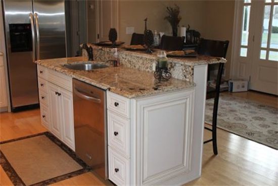 Example of a classic medium tone wood floor kitchen pantry design in New York with a drop-in sink, raised-panel cabinets, light wood cabinets, beige backsplash and stainless steel appliances