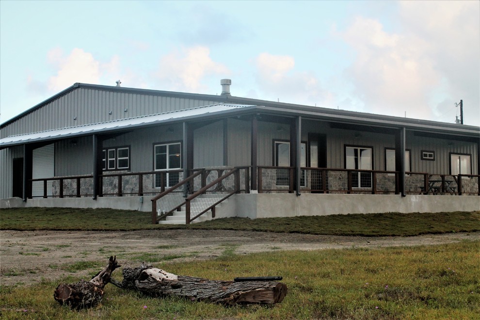 This is an example of a large country one-storey grey house exterior in Other with metal siding, a gable roof and a metal roof.