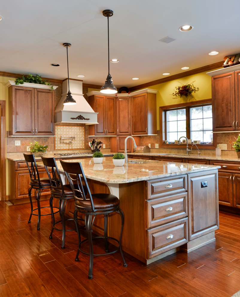 Eat-in kitchen - large transitional u-shaped medium tone wood floor eat-in kitchen idea with beaded inset cabinets, medium tone wood cabinets, granite countertops, beige backsplash, mosaic tile backsplash, stainless steel appliances and an island