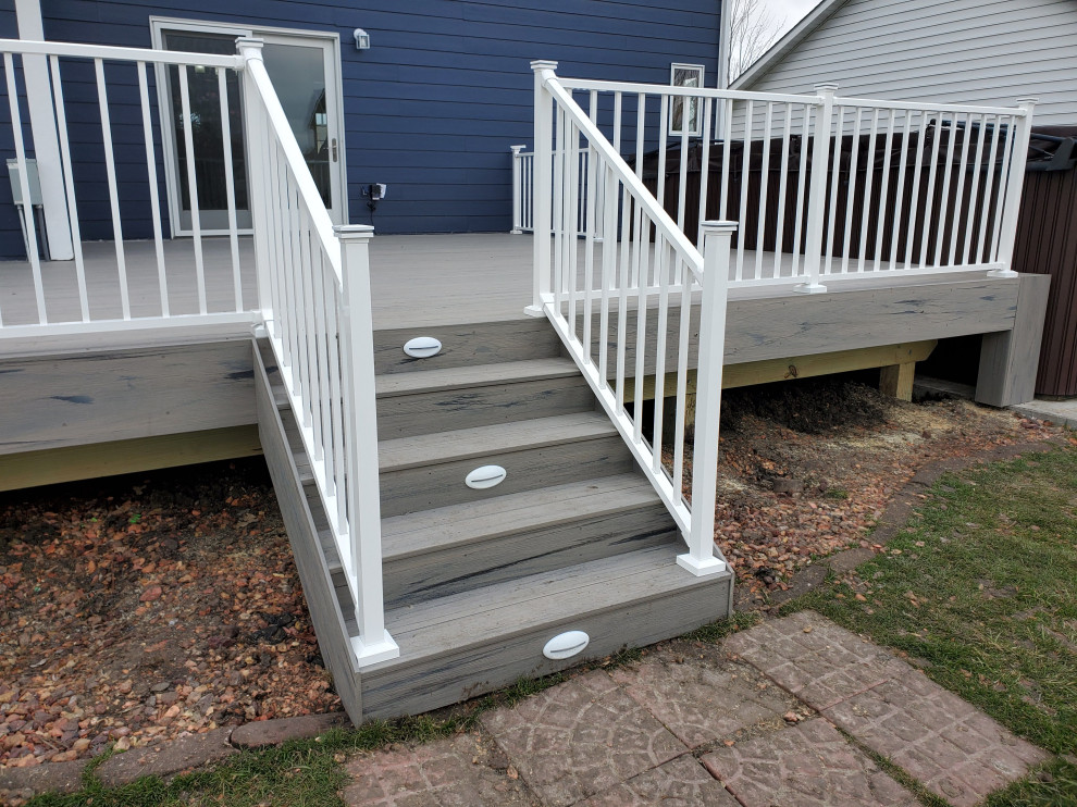 Photo of a mid-sized backyard and ground level deck in Other with with skirting, no cover and metal railing.