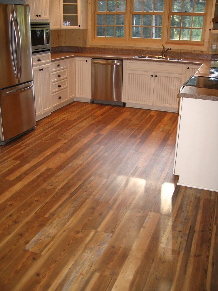 Inspiration for a mid-sized rustic galley light wood floor and beige floor enclosed kitchen remodel with a double-bowl sink, raised-panel cabinets, light wood cabinets, granite countertops, beige backsplash, porcelain backsplash, stainless steel appliances and an island