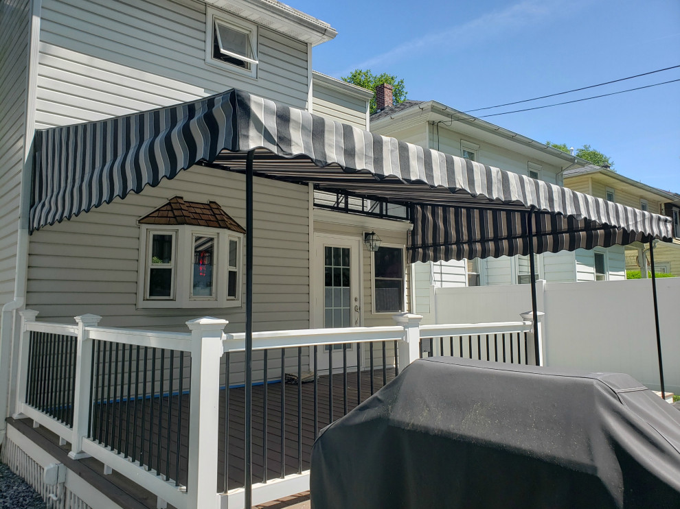 Photo of a large traditional backyard patio in Philadelphia with an awning.