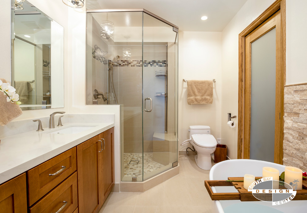 Photo of a mid-sized transitional master bathroom in Los Angeles with shaker cabinets, medium wood cabinets, a hot tub, a corner shower, a one-piece toilet, beige tile, stone tile, beige walls, porcelain floors, an undermount sink, engineered quartz benchtops, beige floor and a hinged shower door.