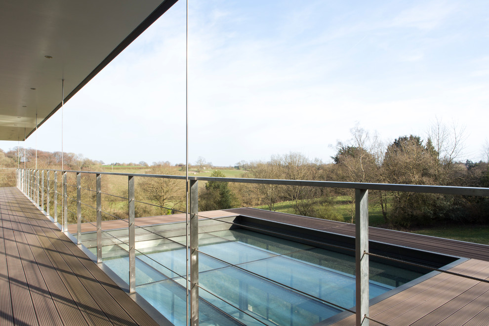 This is an example of a large contemporary metal railing balcony in London with a roof extension.
