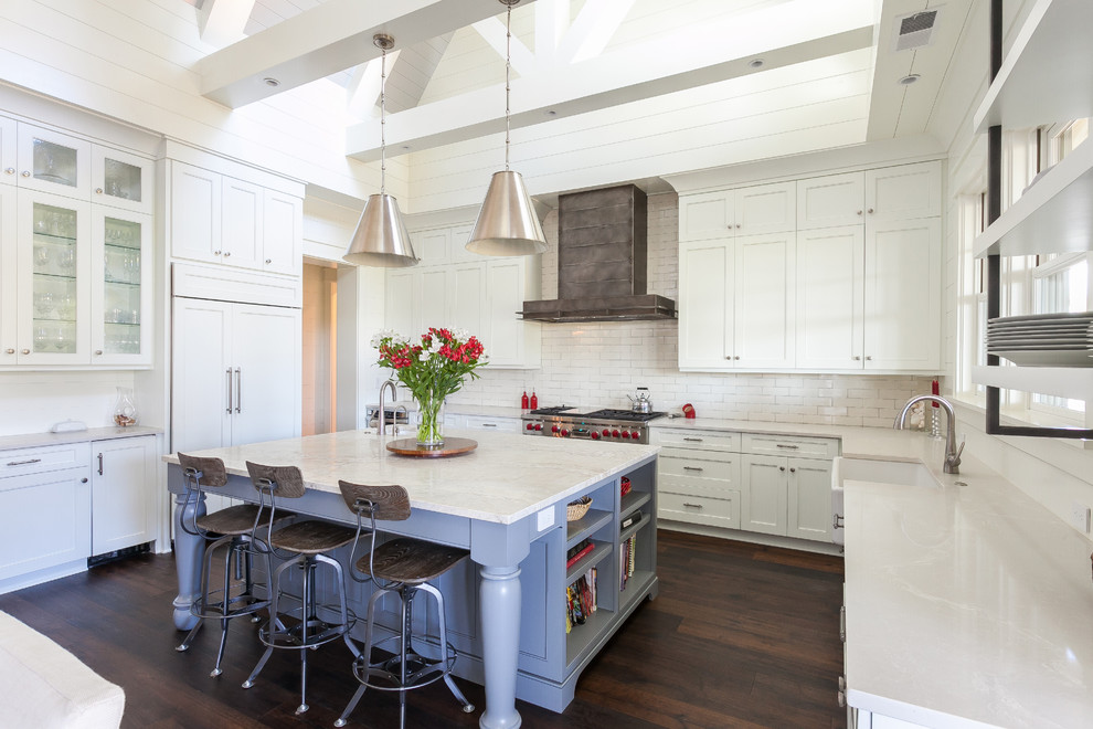 Inspiration for a mid-sized contemporary kitchen in Charleston with a farmhouse sink, shaker cabinets, white cabinets, white splashback, subway tile splashback, stainless steel appliances, dark hardwood floors and with island.