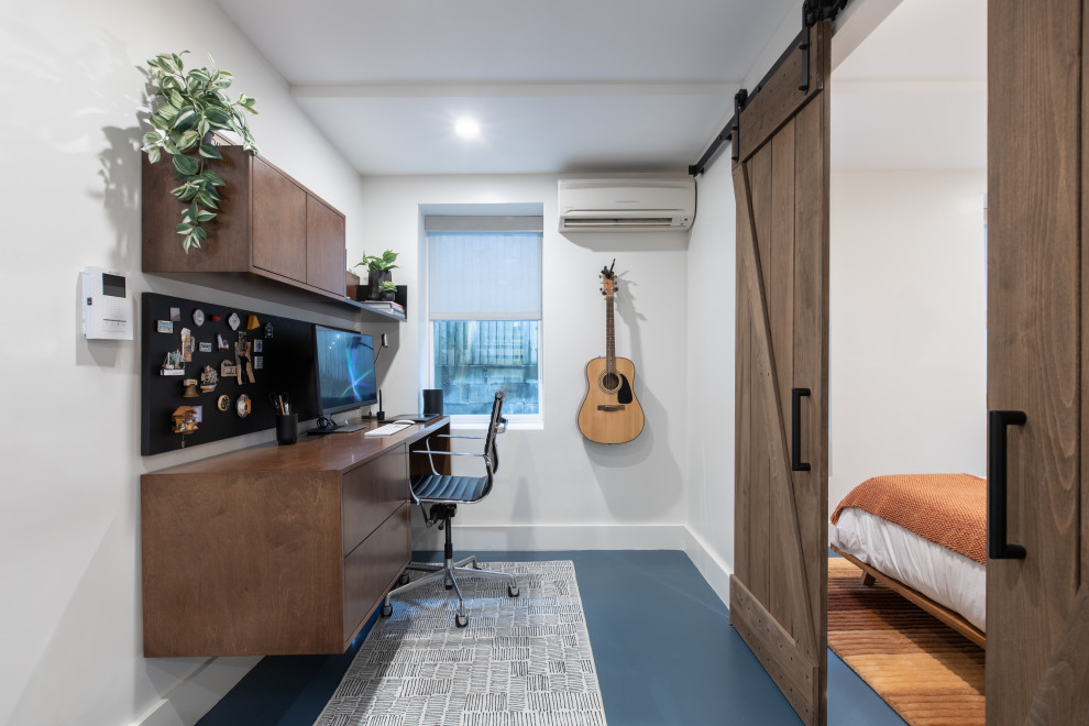 Mittelgroßes Modernes Arbeitszimmer ohne Kamin mit weißer Wandfarbe, Einbau-Schreibtisch und blauem Boden in New York
