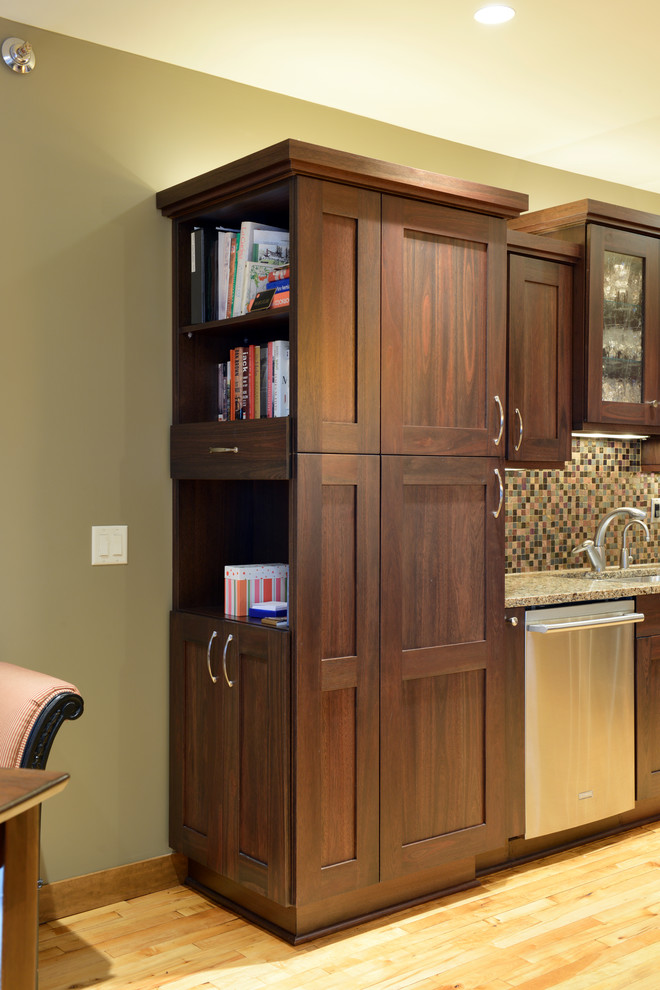 Mid-sized transitional l-shaped light wood floor open concept kitchen photo with an undermount sink, shaker cabinets, dark wood cabinets, quartzite countertops, multicolored backsplash, mosaic tile backsplash, stainless steel appliances and an island