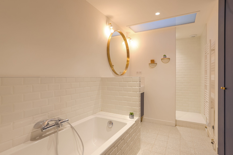 Photo of a large traditional master bathroom in Paris with beaded inset cabinets, blue cabinets, a drop-in tub, a curbless shower, white tile, subway tile, white walls, ceramic floors, a trough sink, solid surface benchtops, white floor, an open shower and white benchtops.