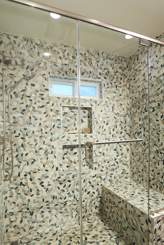 Photo of a mid-sized beach style master bathroom in Los Angeles with shaker cabinets, light wood cabinets, an alcove shower, a one-piece toilet, blue tile, beige walls, a vessel sink, a hinged shower door, pebble tile, pebble tile floors, engineered quartz benchtops and multi-coloured floor.