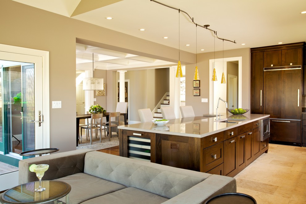 Example of a transitional l-shaped travertine floor eat-in kitchen design in Boston with furniture-like cabinets, dark wood cabinets, concrete countertops, beige backsplash, stone tile backsplash, paneled appliances, gray walls and an island