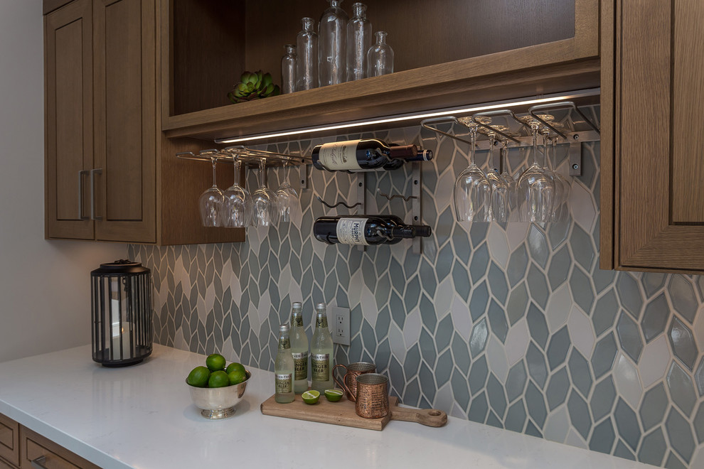 Design ideas for a mid-sized transitional home bar in San Francisco with medium wood cabinets, quartzite benchtops, blue splashback and white benchtop.