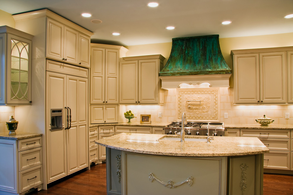 This is an example of a traditional kitchen in Austin with raised-panel cabinets, an undermount sink, beige cabinets, granite benchtops and beige splashback.