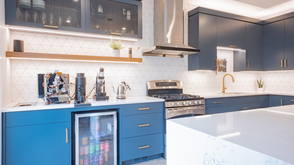 Inspiration for a modern l-shaped vinyl floor and beige floor open concept kitchen remodel in Toronto with flat-panel cabinets, blue cabinets, quartz countertops, white backsplash, ceramic backsplash, stainless steel appliances, an island and white countertops