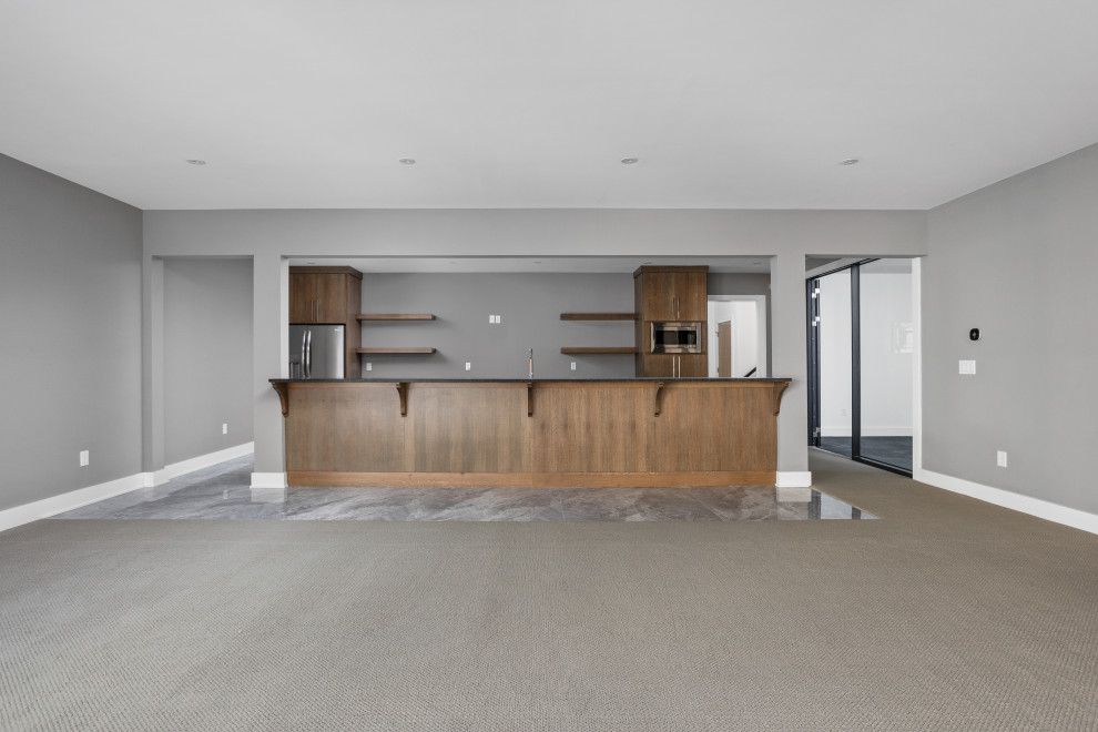 Inspiration pour un très grand sous-sol minimaliste donnant sur l'extérieur avec un bar de salon, un mur gris, moquette et un sol gris.