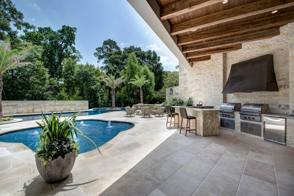 Inspiration for a mediterranean backyard patio in Houston with an outdoor kitchen, tile and a roof extension.