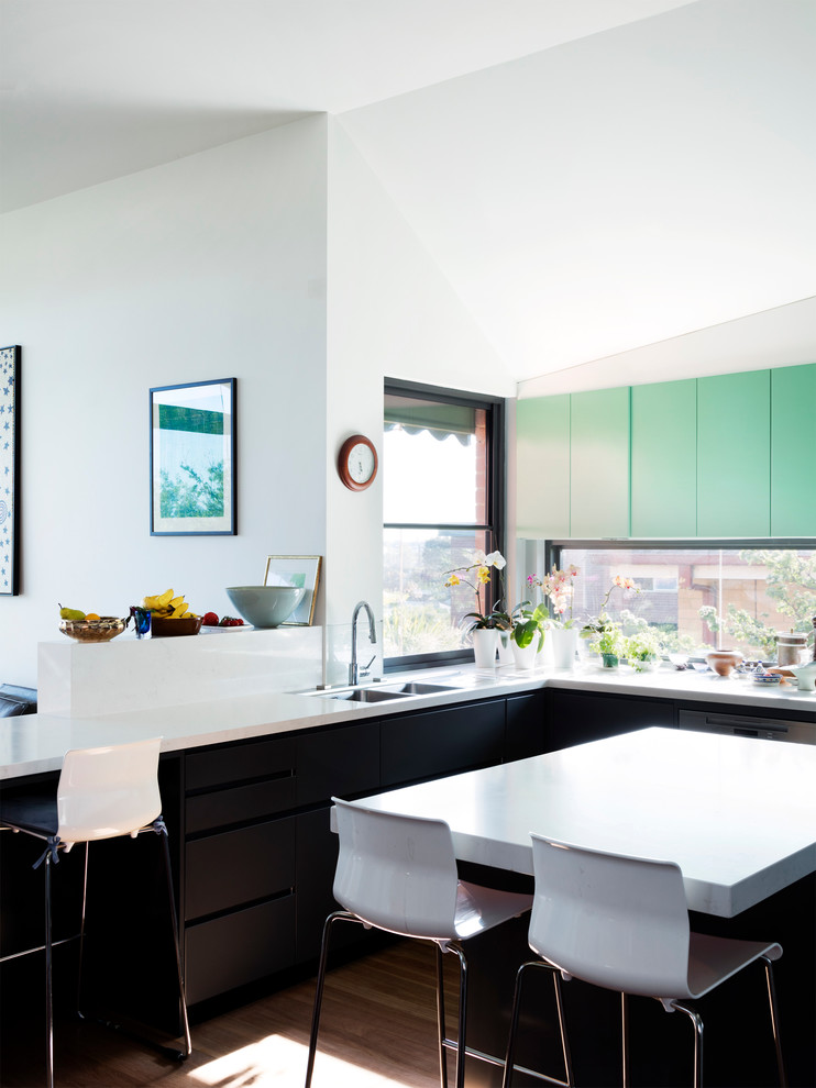 This is an example of a mid-sized contemporary u-shaped eat-in kitchen in Melbourne with a double-bowl sink, black cabinets, granite benchtops, white splashback, stone slab splashback, stainless steel appliances, medium hardwood floors and with island.