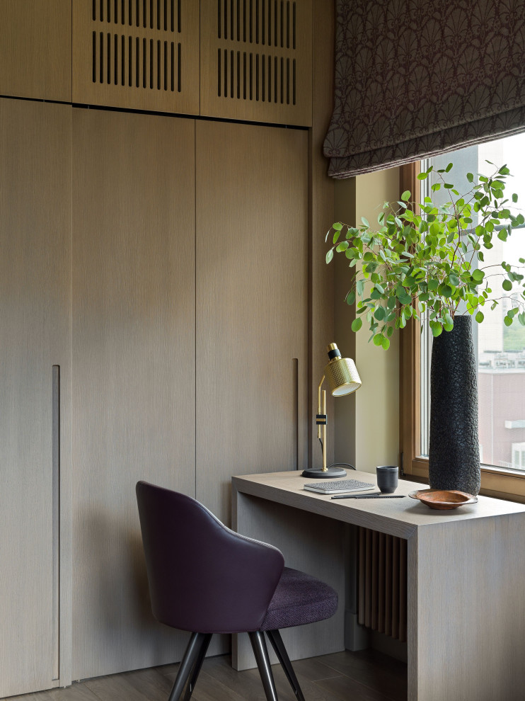 Immagine di un ufficio design di medie dimensioni con pareti beige, pavimento in legno massello medio, scrivania autoportante e pavimento marrone