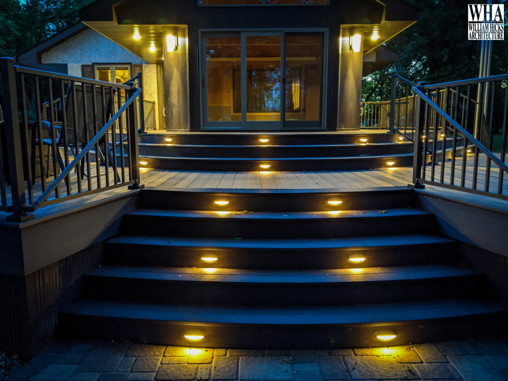 Contemporary backyard and ground level deck in Minneapolis with with skirting, no cover and metal railing.