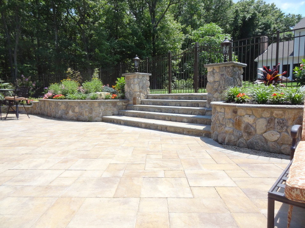 Large transitional backyard patio in New York with a container garden, natural stone pavers and no cover.