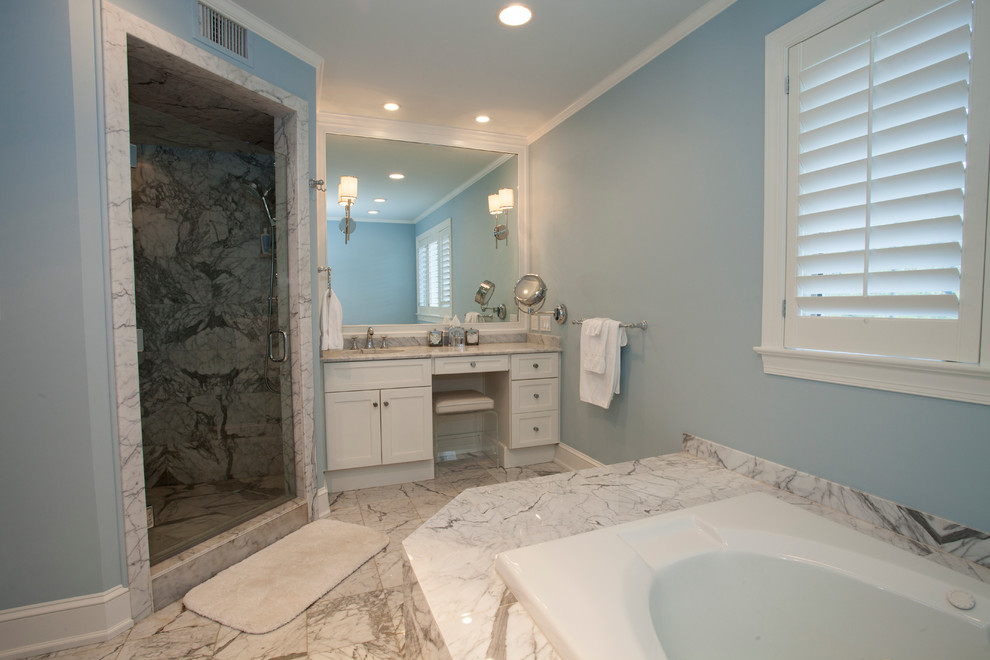 Photo of a mid-sized traditional master bathroom in Philadelphia with an undermount sink, a drop-in tub, a corner shower, shaker cabinets, white cabinets, marble benchtops, white tile, stone tile, blue walls and marble floors.