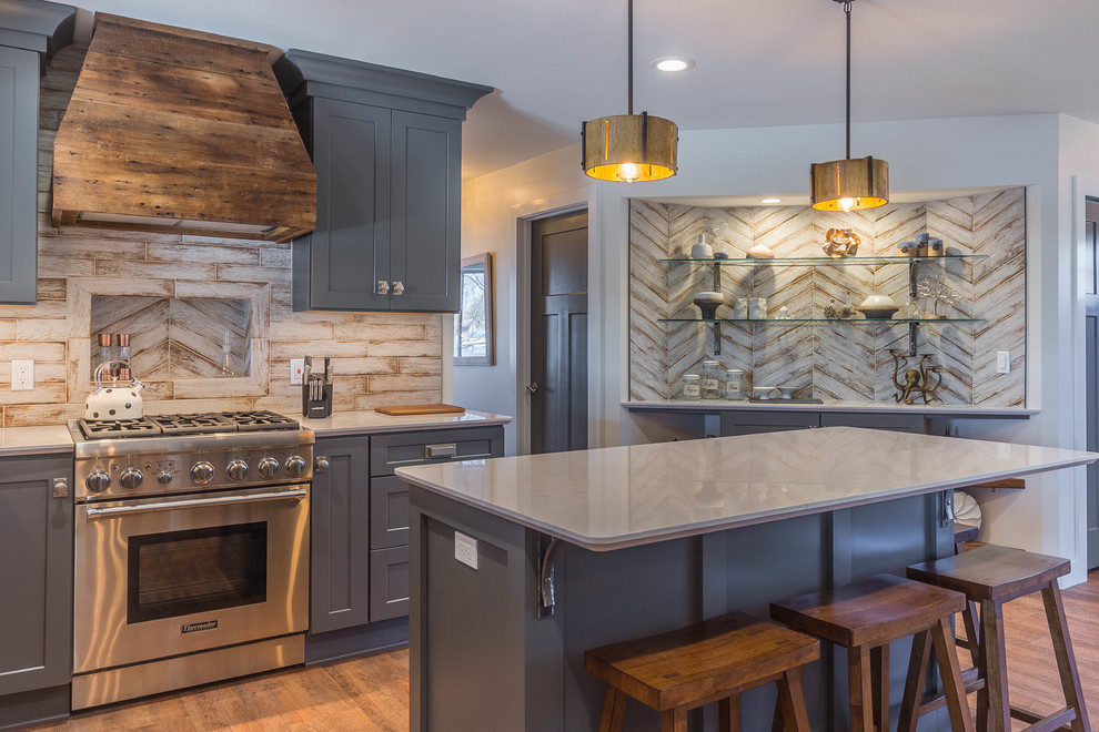 Inspiration for a mid-sized traditional u-shaped eat-in kitchen in Detroit with an undermount sink, shaker cabinets, grey cabinets, quartz benchtops, white splashback, porcelain splashback, stainless steel appliances, vinyl floors, with island and brown floor.
