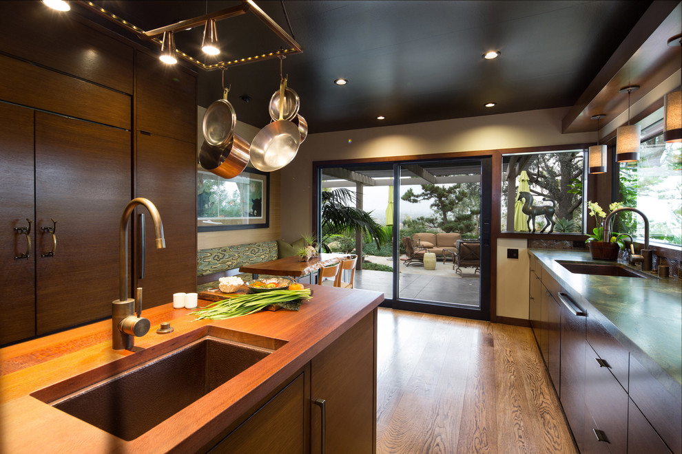 Photo of a mid-sized asian l-shaped kitchen in Los Angeles with an undermount sink, flat-panel cabinets, medium wood cabinets, quartzite benchtops, brown splashback, ceramic splashback, panelled appliances, medium hardwood floors and with island.