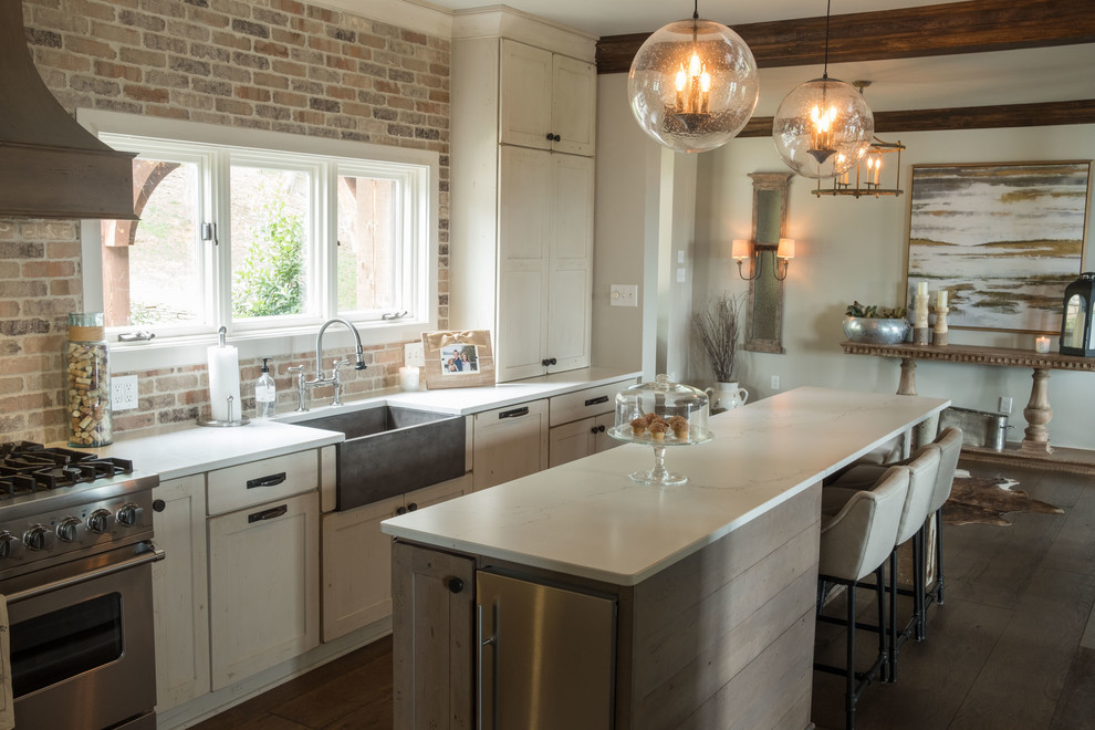Open concept kitchen - large transitional galley dark wood floor and brown floor open concept kitchen idea with a farmhouse sink, shaker cabinets, quartz countertops, brown backsplash, brick backsplash, stainless steel appliances and an island