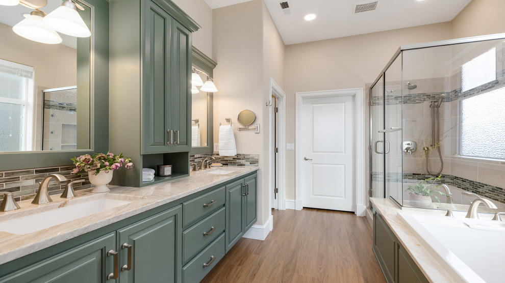 Inspiration for a mid-sized transitional master bathroom in Other with raised-panel cabinets, green cabinets, a drop-in tub, beige tile, beige walls, an undermount sink, quartzite benchtops, brown floor, a hinged shower door, beige benchtops, an enclosed toilet, a double vanity and a built-in vanity.