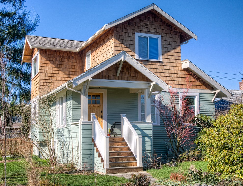 Mid-sized arts and crafts two-storey green exterior in Seattle with wood siding.