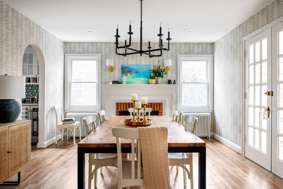 Inspiration for a mid-sized transitional separate dining room in DC Metro with grey walls, medium hardwood floors, a standard fireplace, a wood fireplace surround, brown floor and wallpaper.