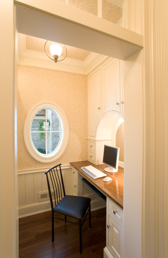 Design ideas for a traditional home office in Minneapolis with beige walls, dark hardwood floors and a built-in desk.