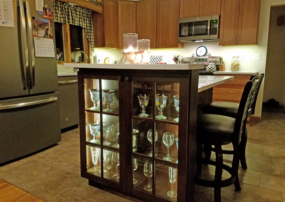 Example of a mid-sized transitional l-shaped ceramic tile and green floor eat-in kitchen design with an undermount sink, shaker cabinets, medium tone wood cabinets, quartz countertops, stainless steel appliances, an island and white countertops