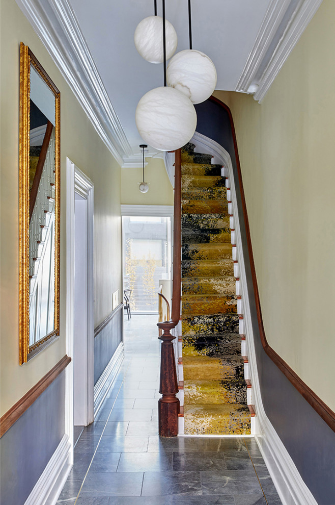 Inspiration for a mid-sized traditional wood straight staircase in New York with painted wood risers and wood railing.