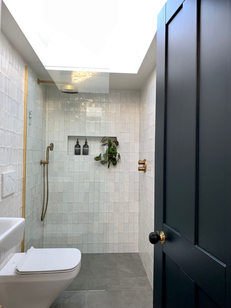 This is an example of a medium sized modern grey and white shower room bathroom in London with a walk-in shower, a wall mounted toilet, metro tiles, white walls, slate flooring, a wall-mounted sink, grey floors, an open shower, feature lighting and a single sink.