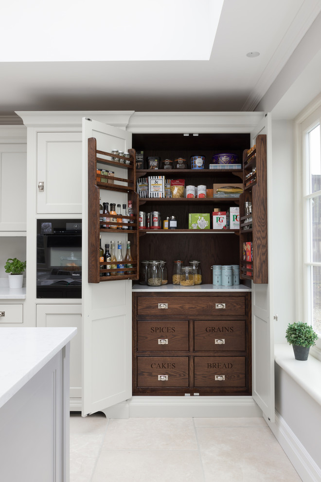 Inspiration for a large transitional l-shaped kitchen pantry in Other with shaker cabinets, white cabinets, black appliances, with island, beige floor and white benchtop.