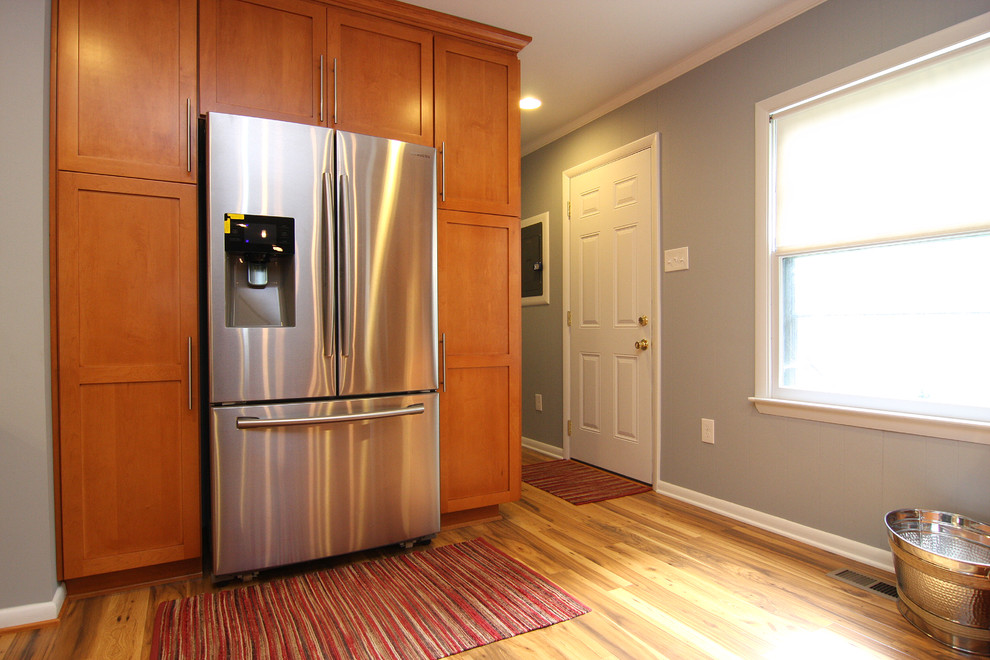 Eat-in kitchen - large transitional u-shaped medium tone wood floor eat-in kitchen idea with a drop-in sink, recessed-panel cabinets, medium tone wood cabinets, laminate countertops, white backsplash, ceramic backsplash, stainless steel appliances and a peninsula
