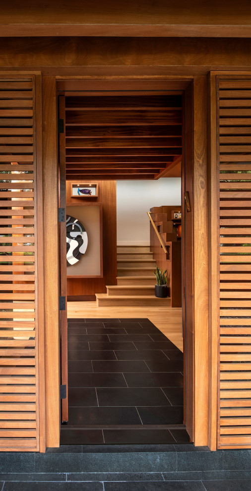 Modelo de entrada minimalista con suelo de granito, puerta simple y puerta de madera en tonos medios