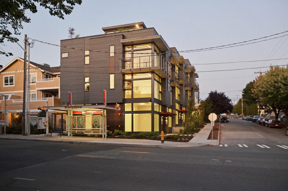Mid-sized contemporary three-storey grey townhouse exterior in Seattle with concrete fiberboard siding and a flat roof.