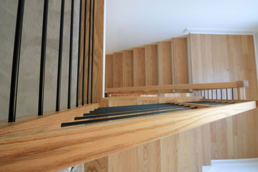 Réalisation d'un escalier peint flottant design de taille moyenne avec des marches en bois, un garde-corps en matériaux mixtes et du lambris de bois.