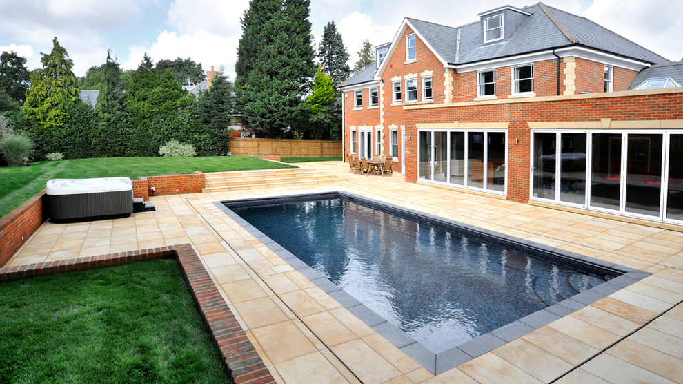Photo of a large modern front yard rectangular lap pool in London with a pool house.