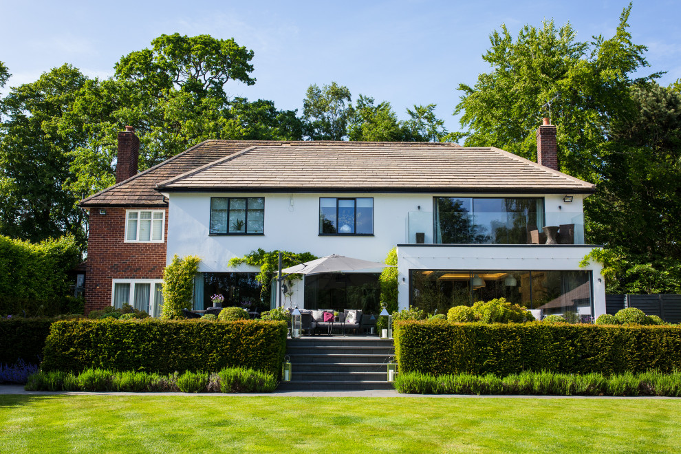 Photo of a transitional two-storey white house exterior in Cheshire with a hip roof and a shingle roof.