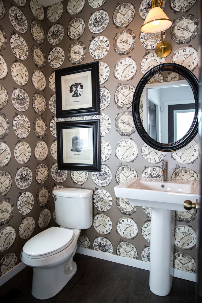 Photo of a transitional powder room in Calgary with a pedestal sink, a two-piece toilet, multi-coloured walls and dark hardwood floors.