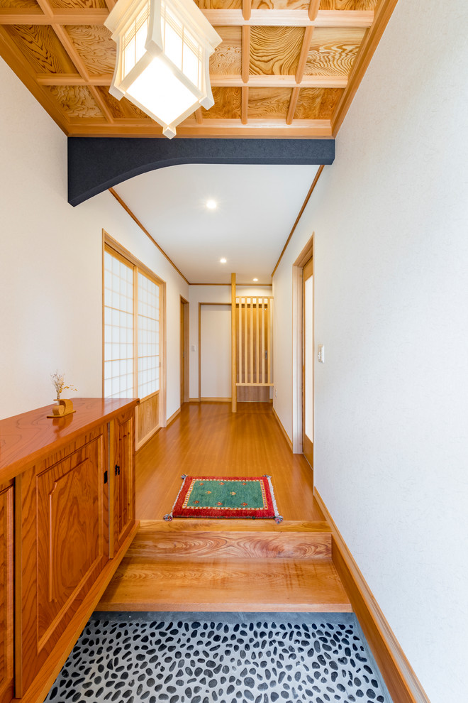 Asian entry hall in Other with white walls and black floor.