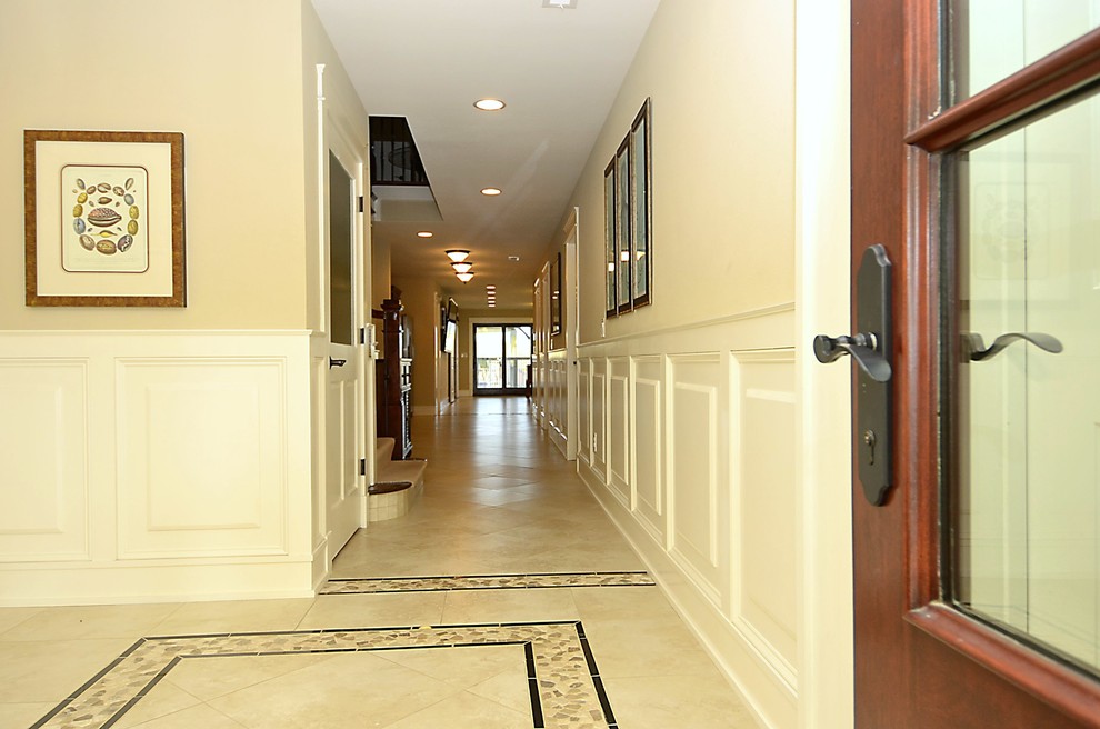 Mid-sized beach style hallway in Other with beige walls, ceramic floors and beige floor.