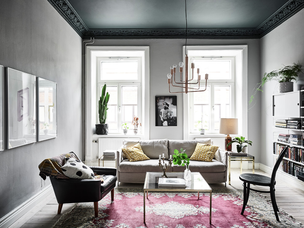 Design ideas for a mid-sized eclectic formal living room in Gothenburg with grey walls and light hardwood floors.