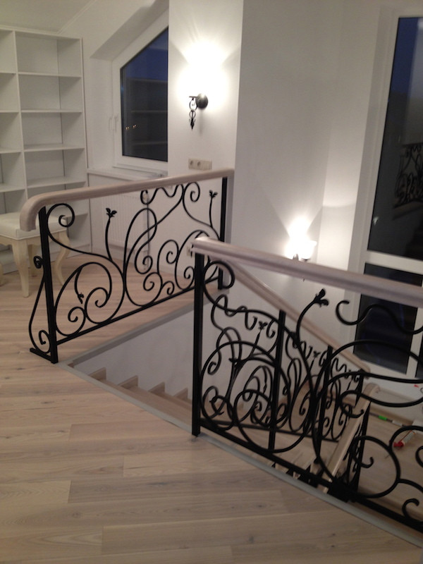 Photo of a medium sized traditional wood u-shaped metal railing staircase in Moscow with wood risers and wallpapered walls.
